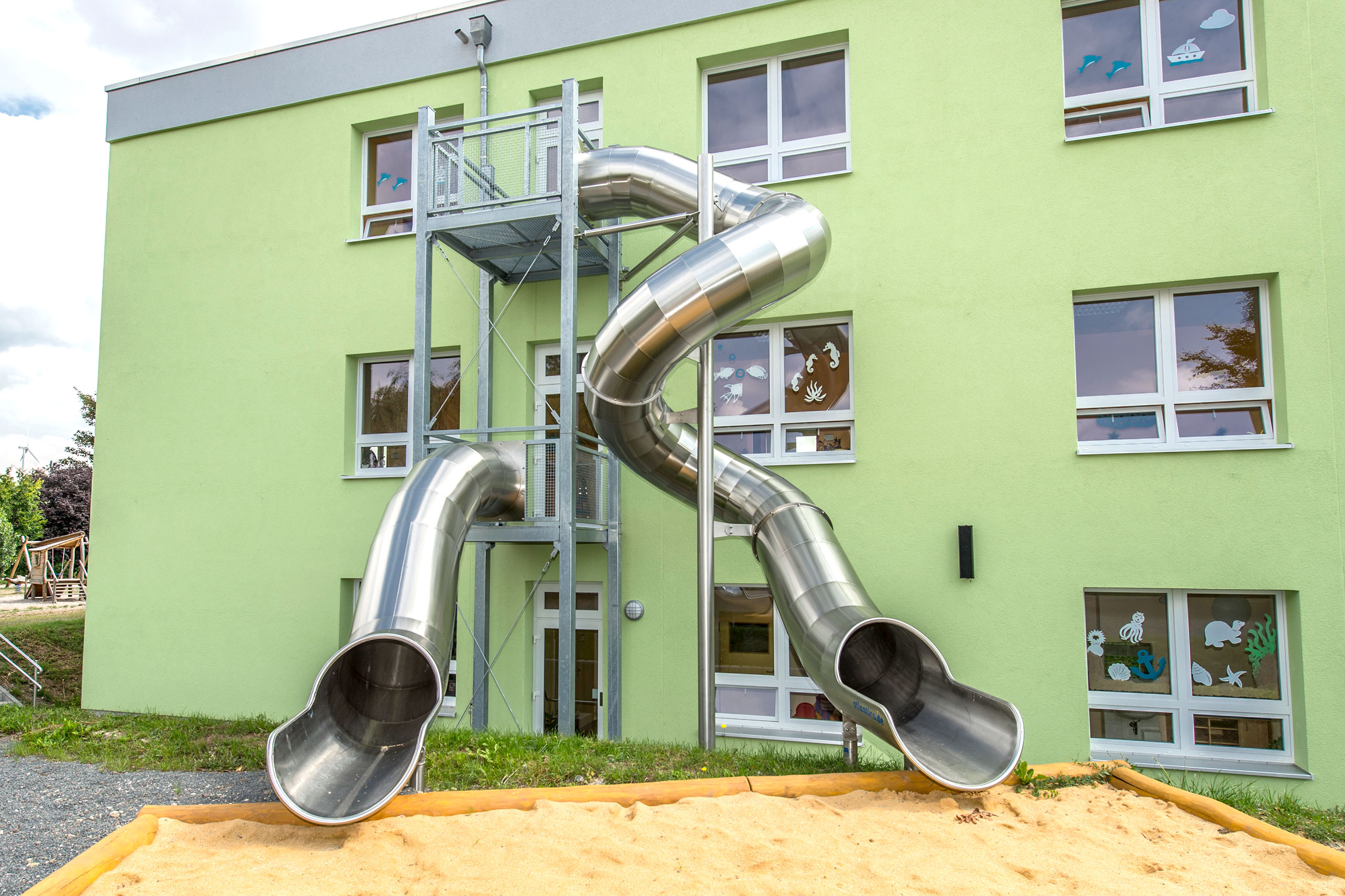 2 atlantics Edelstahlrutschen an einem grünen Haus, die als Evakuierungsrutschen genutzt werden, im Kinderland Hainleite in Westerengel