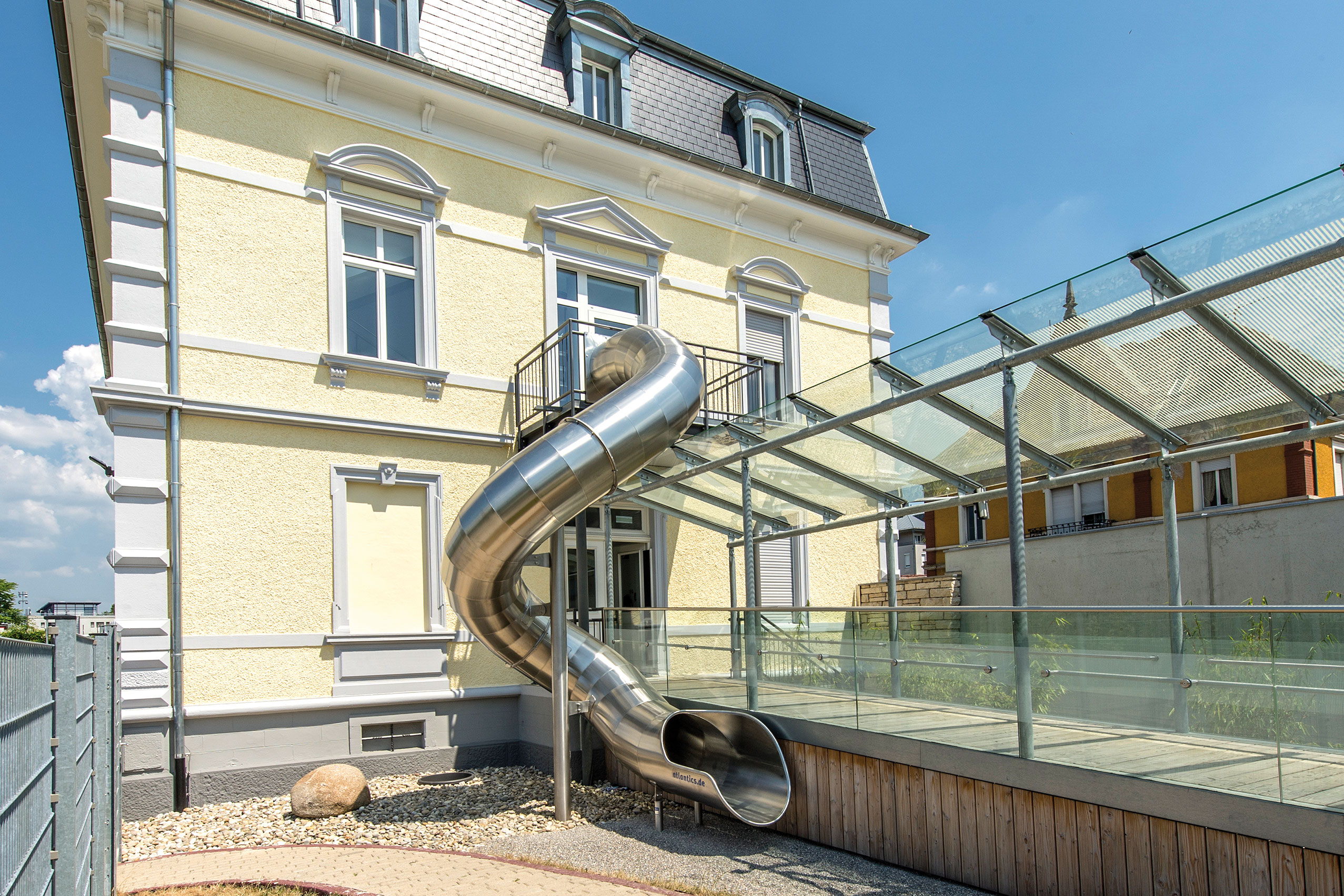 Die atlantics Edelstahlrutsche führt vom oberen Stock in den Innenhof der Kita Villa Lila in Lörrach und dient der schnellen Evakuierung bei Gefahrensituationen