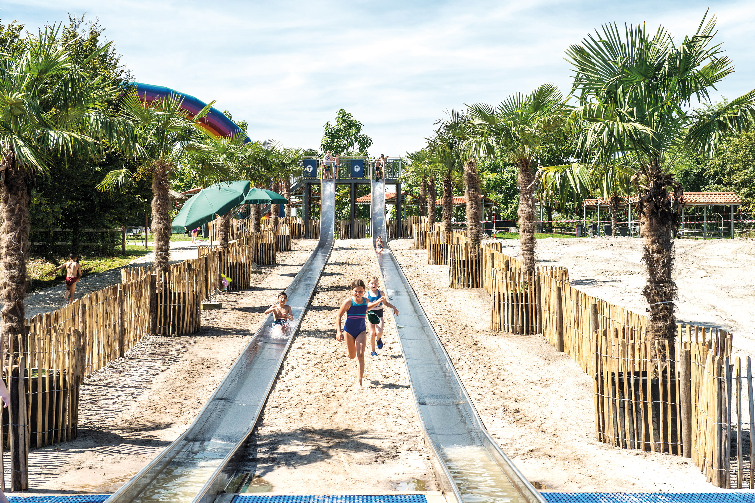 2 atlantics Edelstahl Wasserrutschen im Freizeitpark Irrland, Kinder rennen durch den Sand