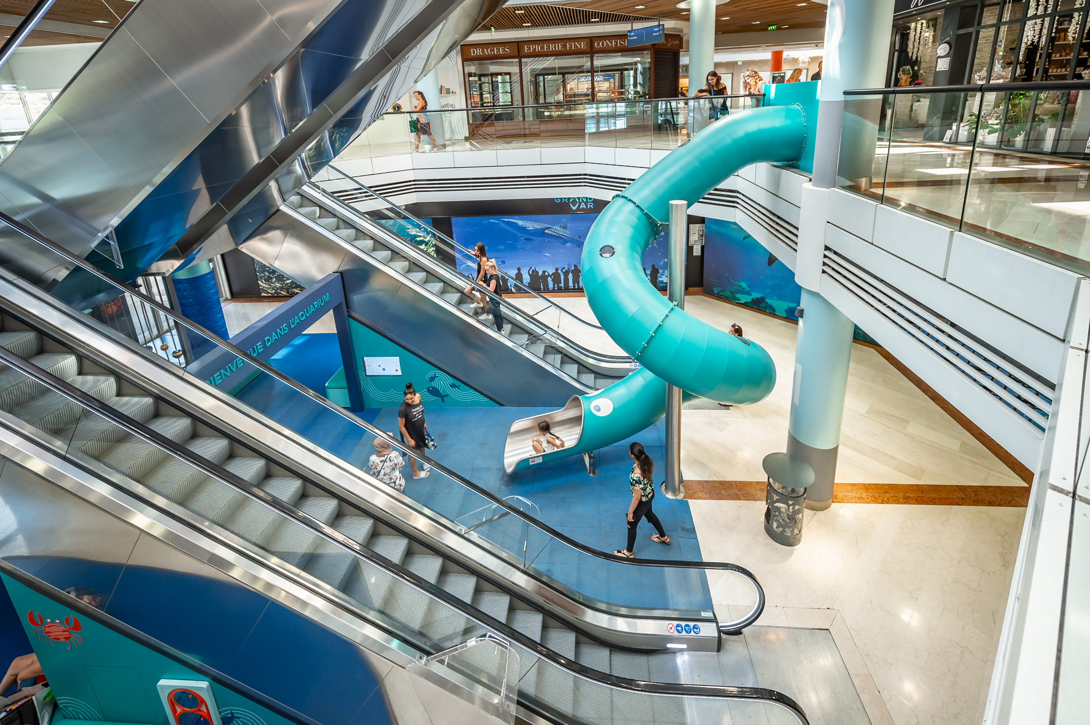 Türkisfarbene indoor Edelstahl-Tunnelrutsche für Kinder in einem Shoppingcenter in Frankreich