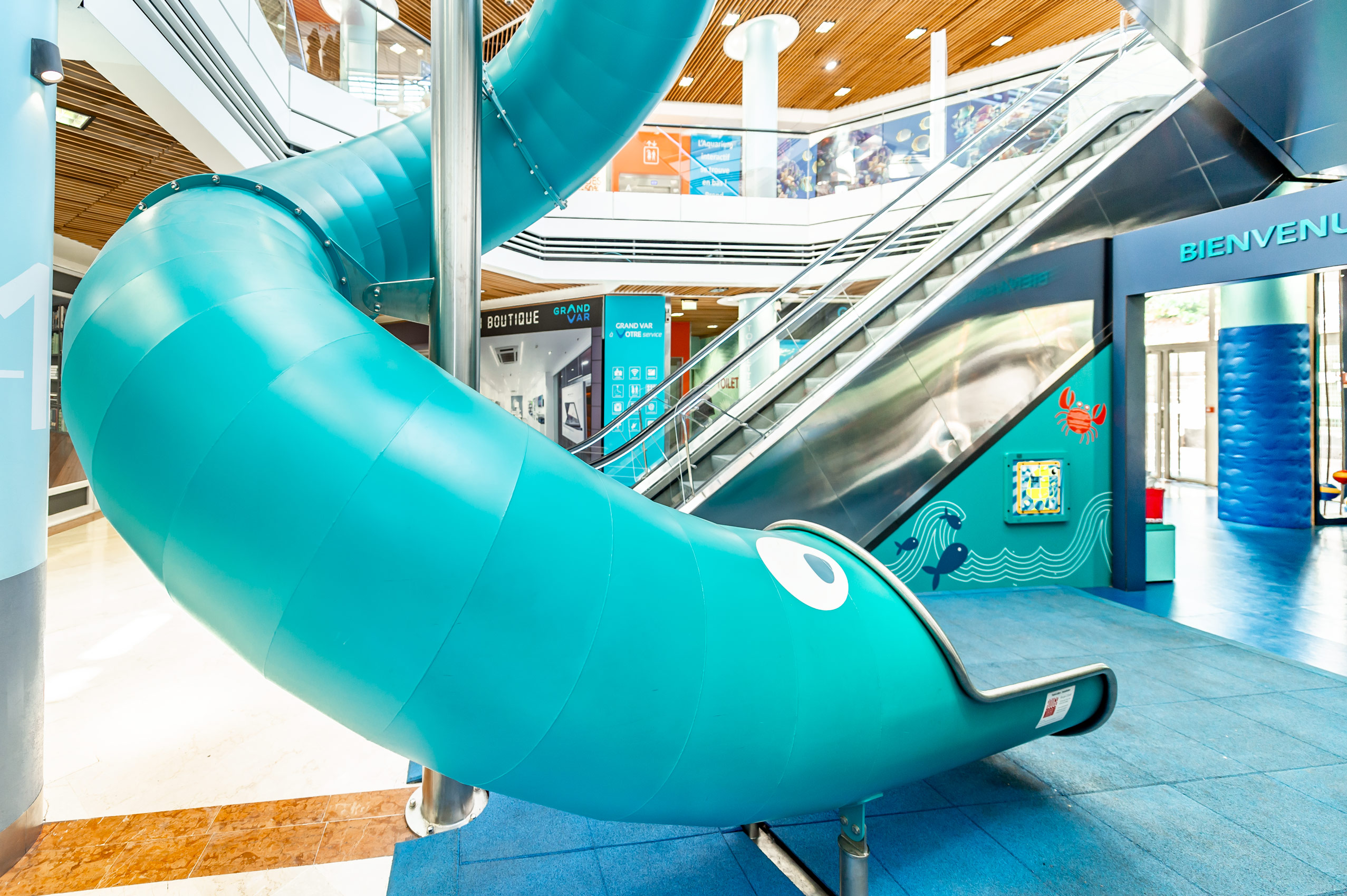 Türkisfarbene indoor Edelstahl-Tunnelrutsche in einem Shoppingcenter in Frankreich