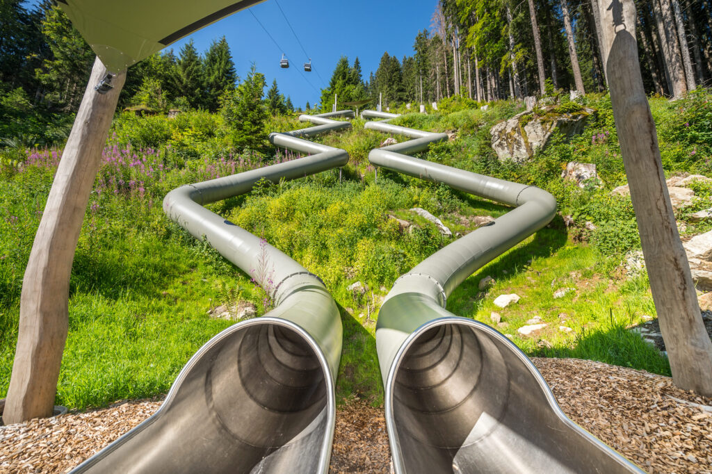 atlantics rutschkanor i rostfritt stål i Waldrutschenpark-Golm i Österrike, tunnelrutschkanor, sluttningsrutschkanor, skid- och vandringsområden