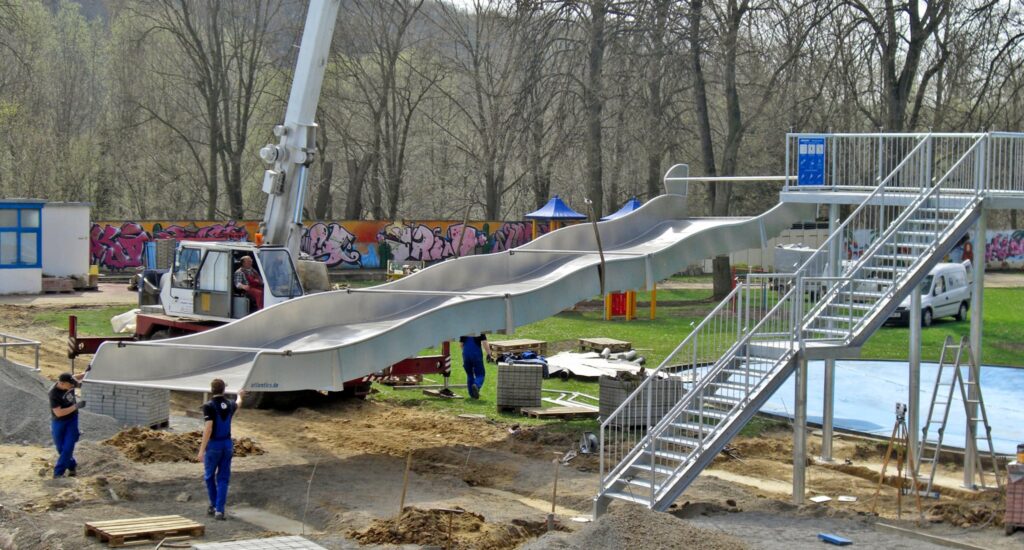 Le montage du toboggan aquatique large avec plateforme daccès est effectué à laide dune grue par les monteurs de lentreprise atlantics