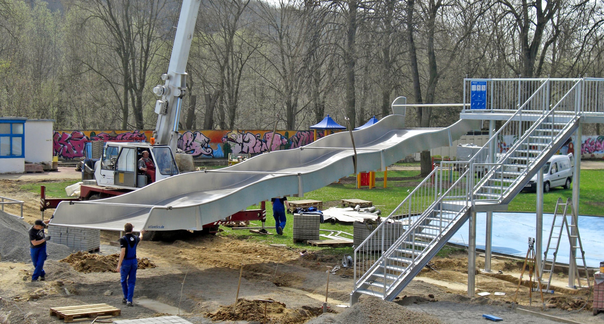 Die Montage der Breitwasserrutsche mit Aufstiegspodest erfolgt mittels Kran durch die Monteure der Firma atlantics