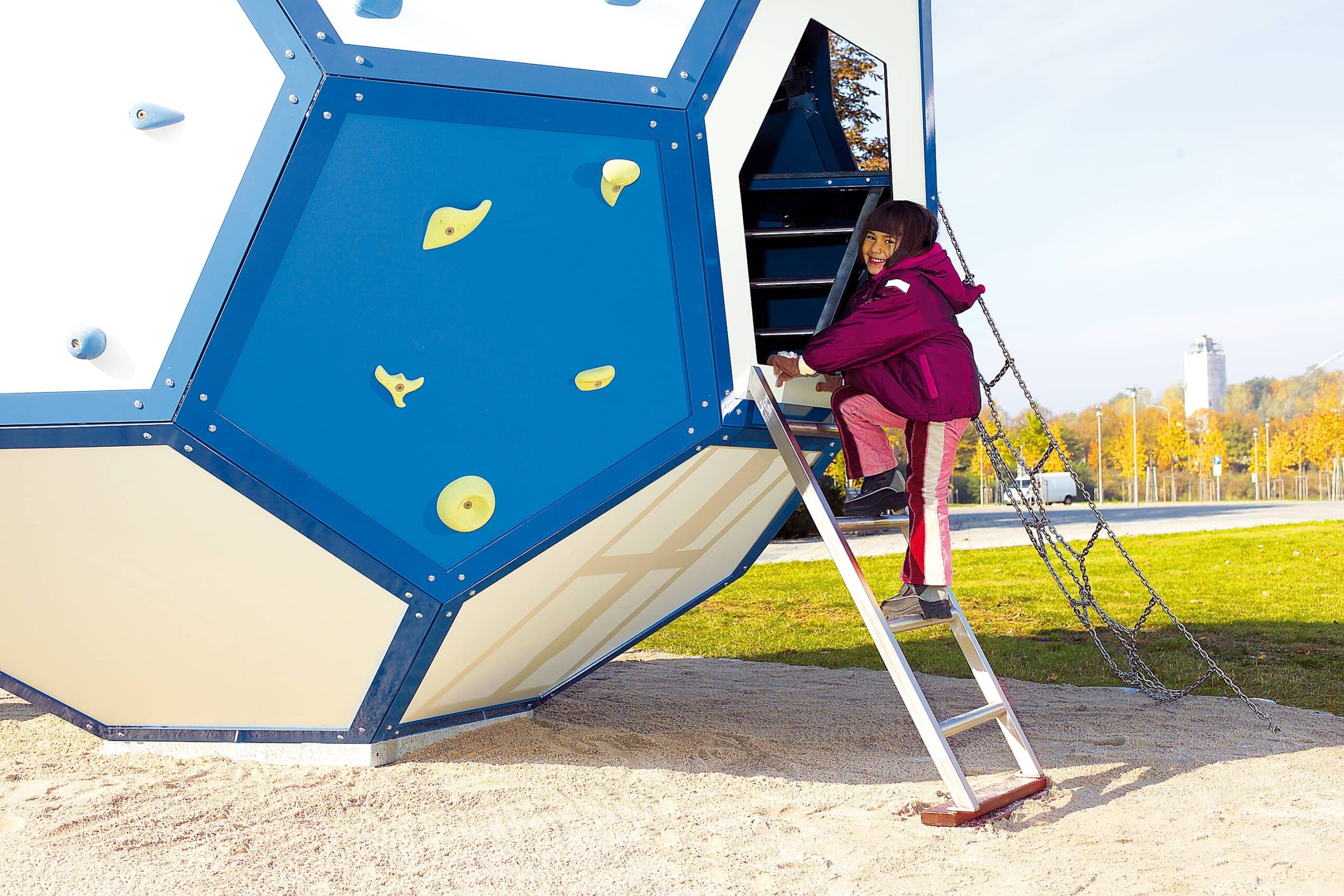 Mädchen klettert am atlantics Spezialprodukt Spielfußball aus Edelstahl