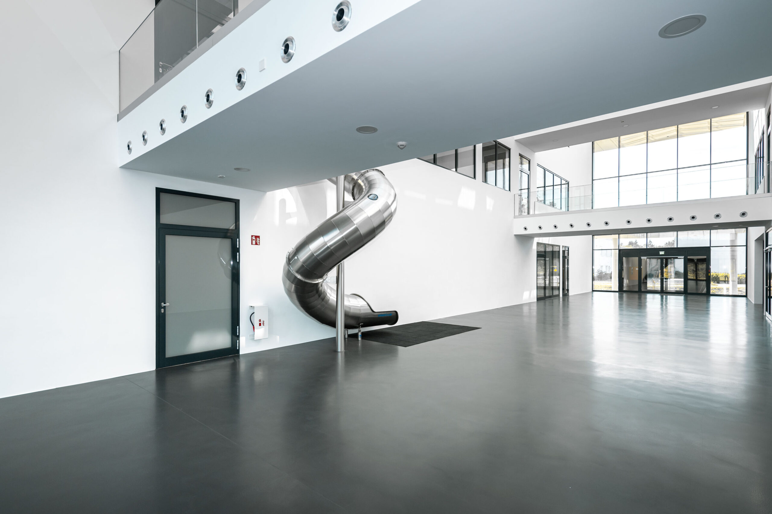 atlantics Edelstahlrutsche im Bürogebäude Postnova Analytics in Landsberg am Lech, Tunnelrutsche, Bürorutsche, Indoorrutsche