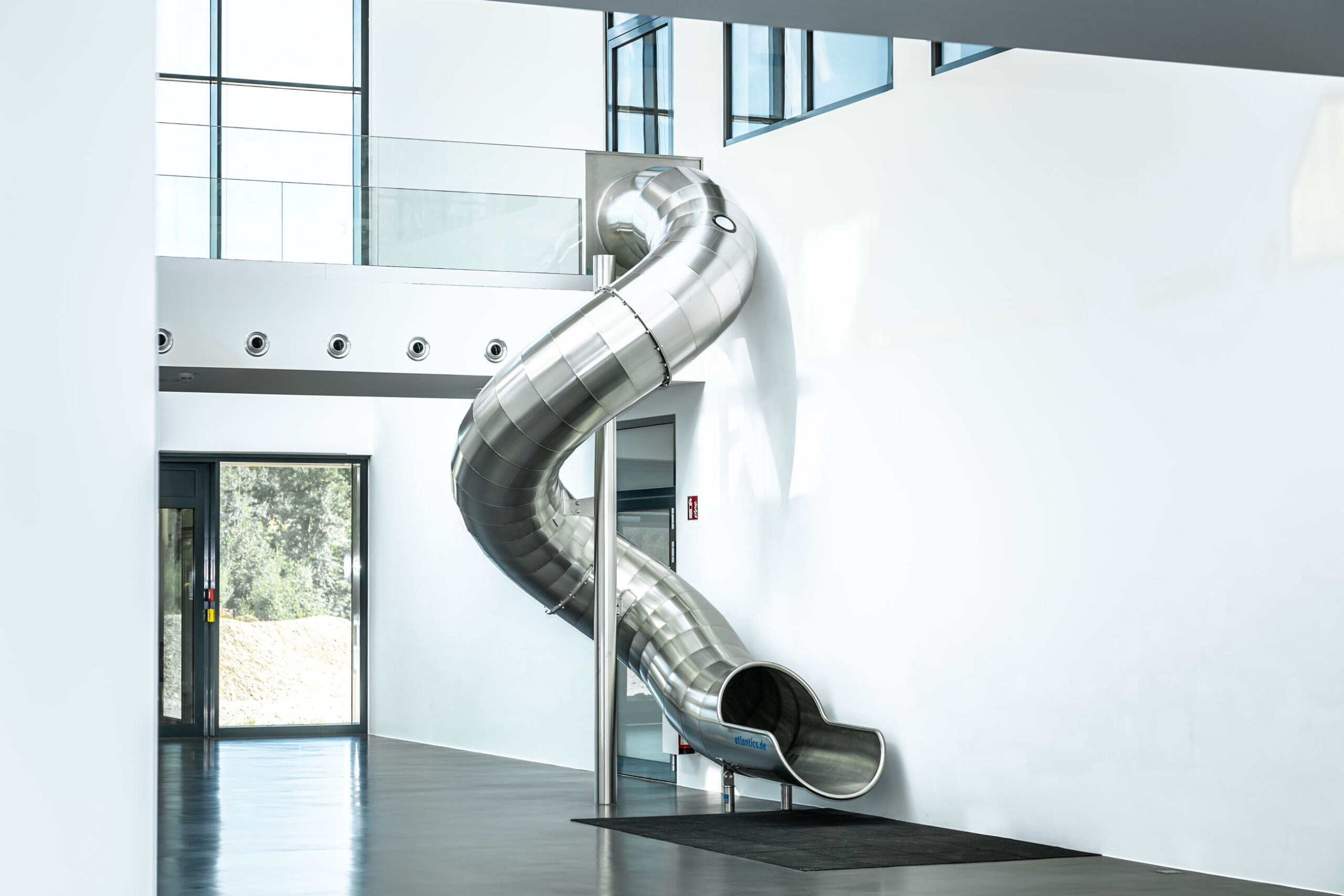 atlantics Edelstahlrutsche im Bürogebäude Postnova Analytics in Landsberg am Lech, Tunnelrutsche, Bürorutsche, Indoorrutsche