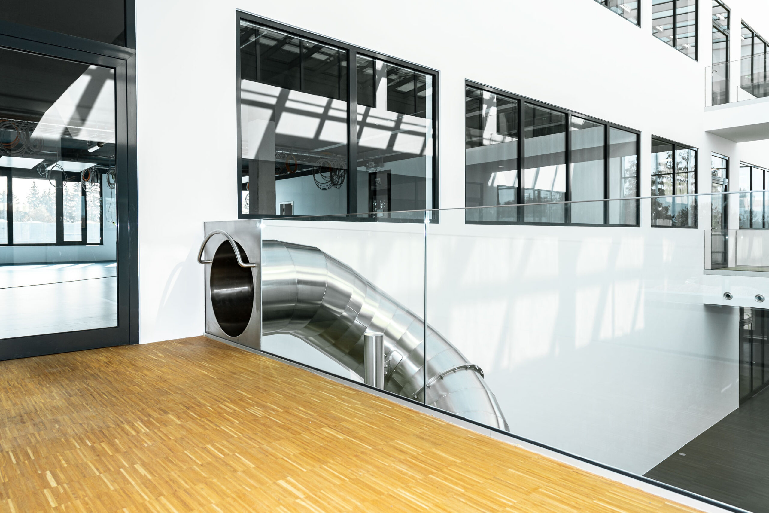atlantics Edelstahlrutsche im Bürogebäude Postnova Analytics in Landsberg am Lech, Tunnelrutsche, Bürorutsche, Indoorrutsche