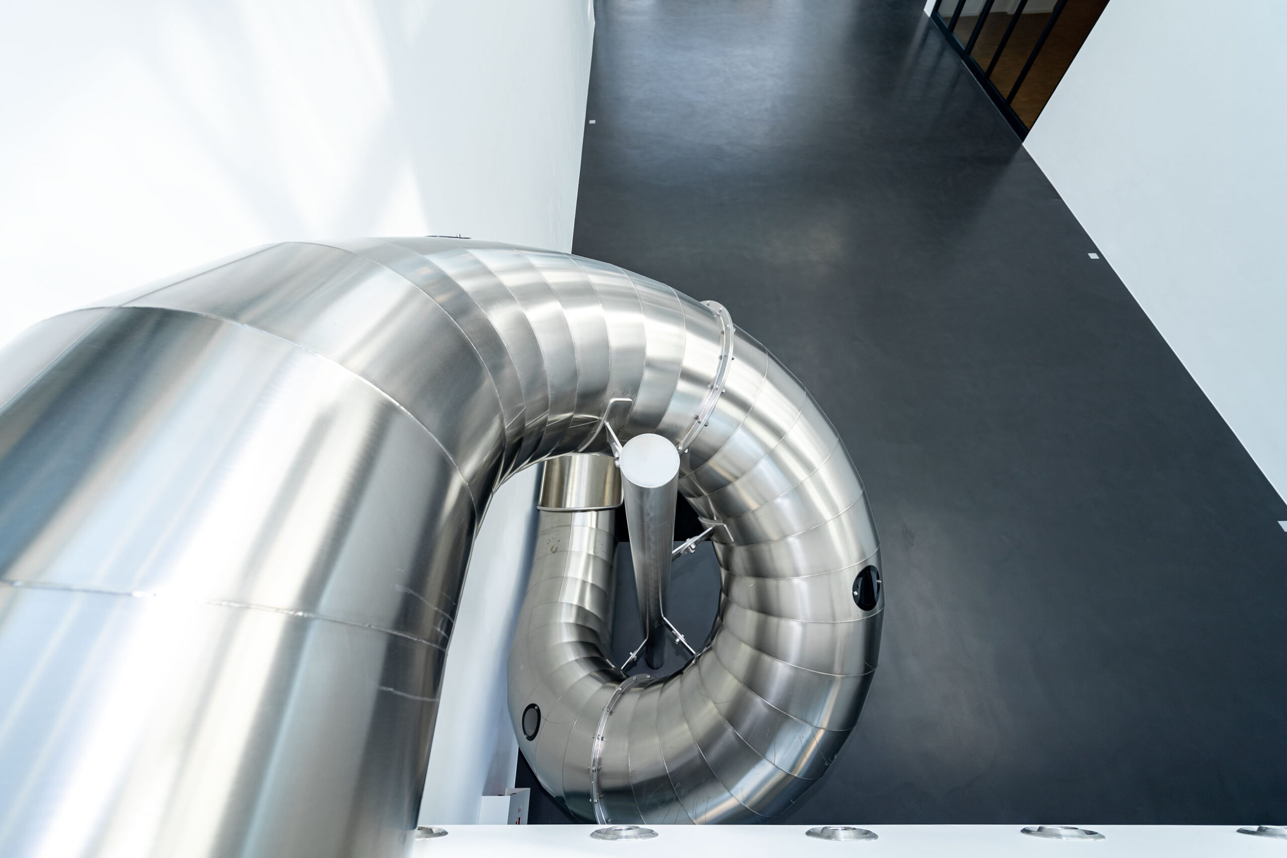 atlantics Edelstahlrutsche im Bürogebäude Postnova Analytics in Landsberg am Lech, Tunnelrutsche, Bürorutsche, Indoorrutsche