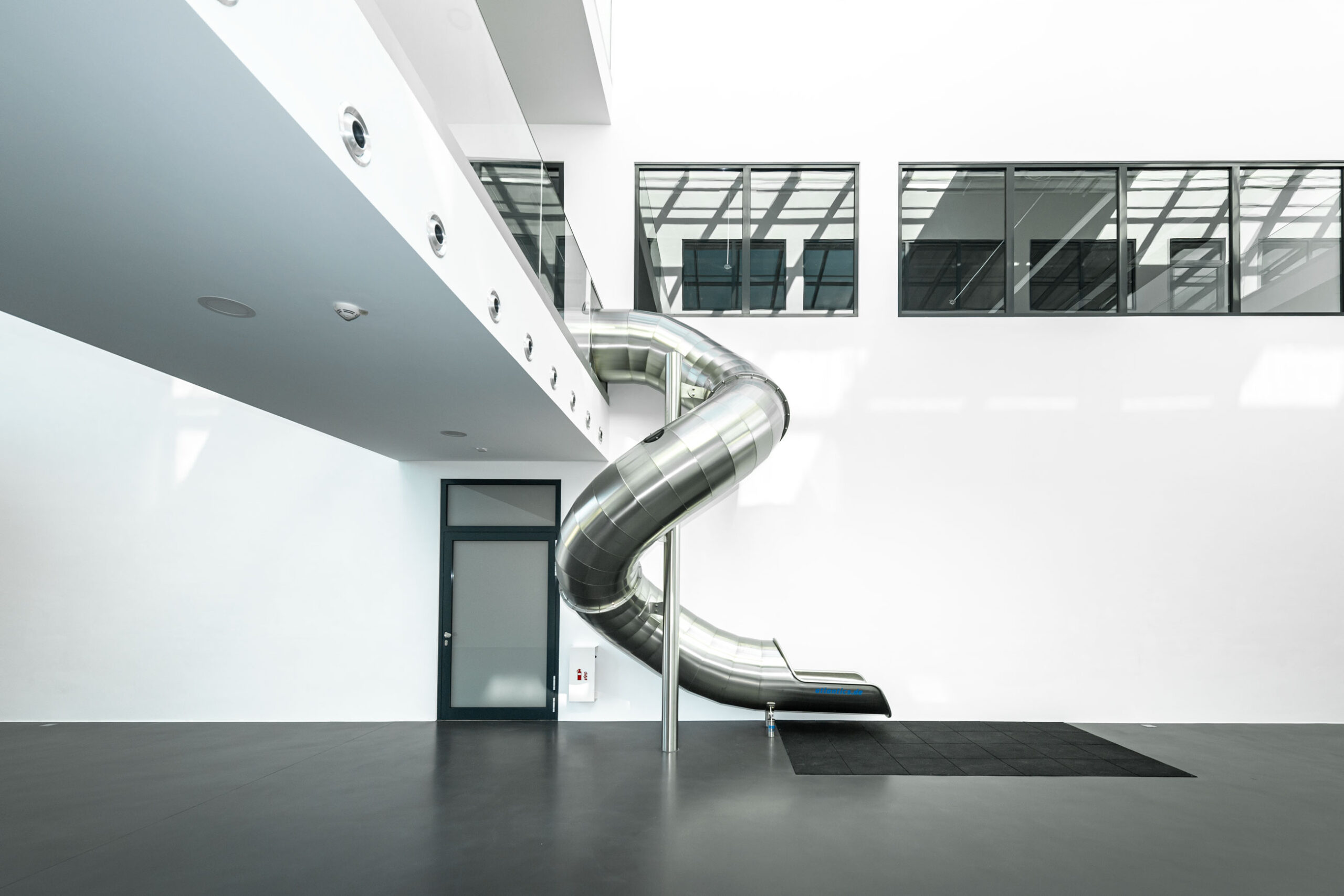 atlantics Edelstahlrutsche im Bürogebäude Postnova Analytics in Landsberg am Lech, Tunnelrutsche, Bürorutsche, Indoorrutsche