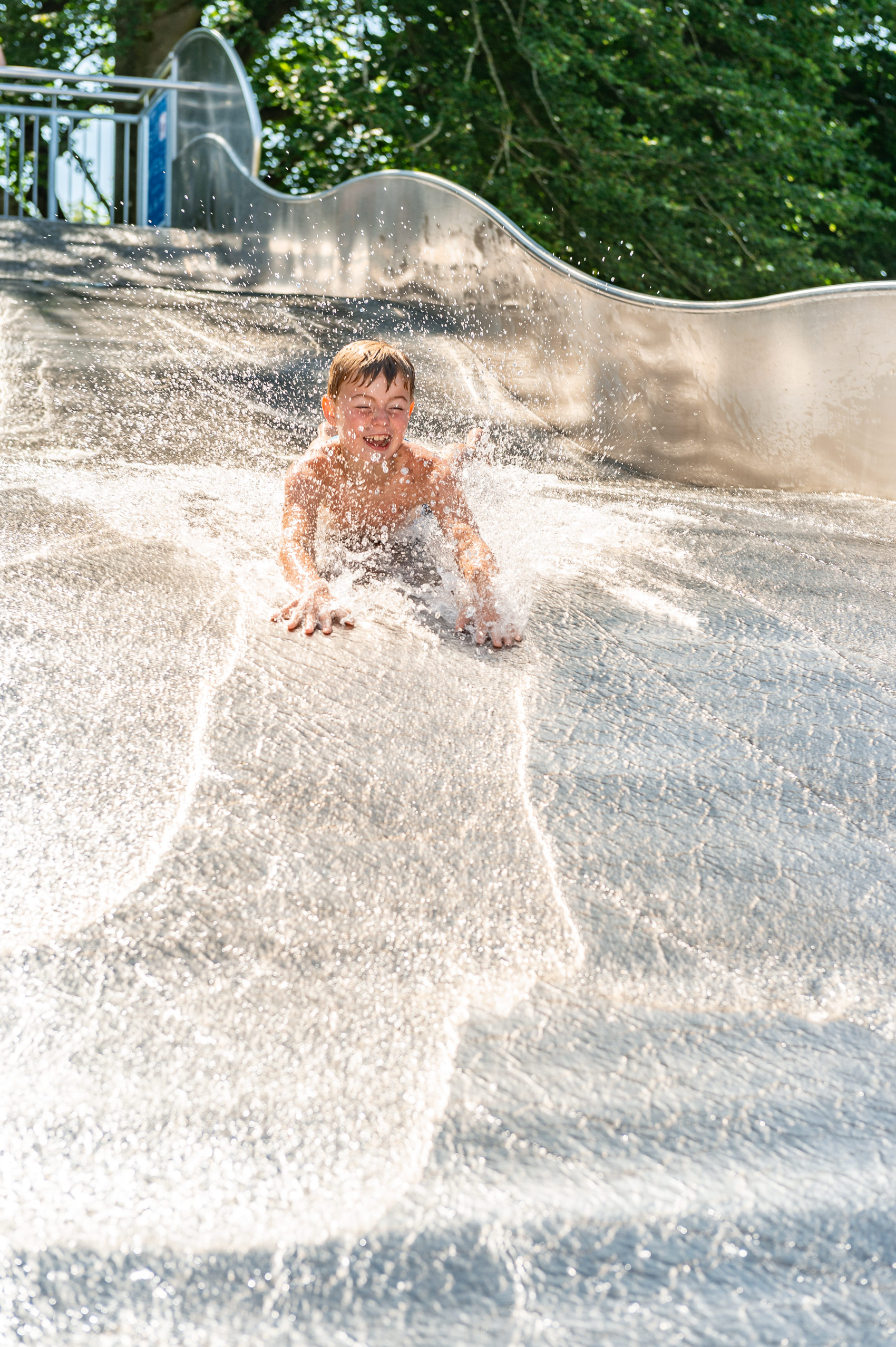 Kind hat Badespaß auf der Breitwasserrutsche mit Landebecken im Franz-Haberlander-Freibad in Traunreut