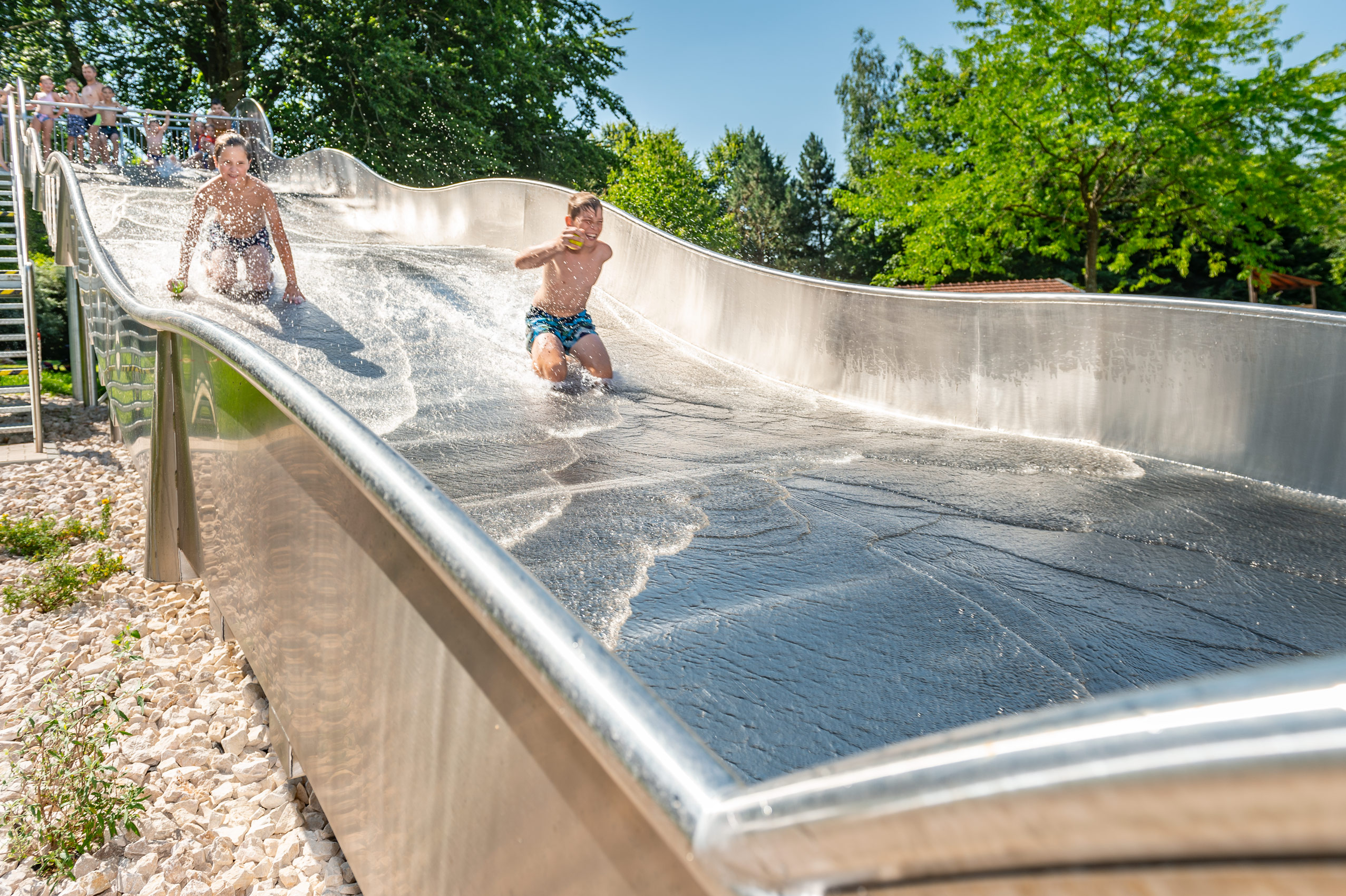 Kinder haben Spaß auf der Breitwasserrutsche mit Landebecken im Franz-Haberlander-Freibad in Traunreut