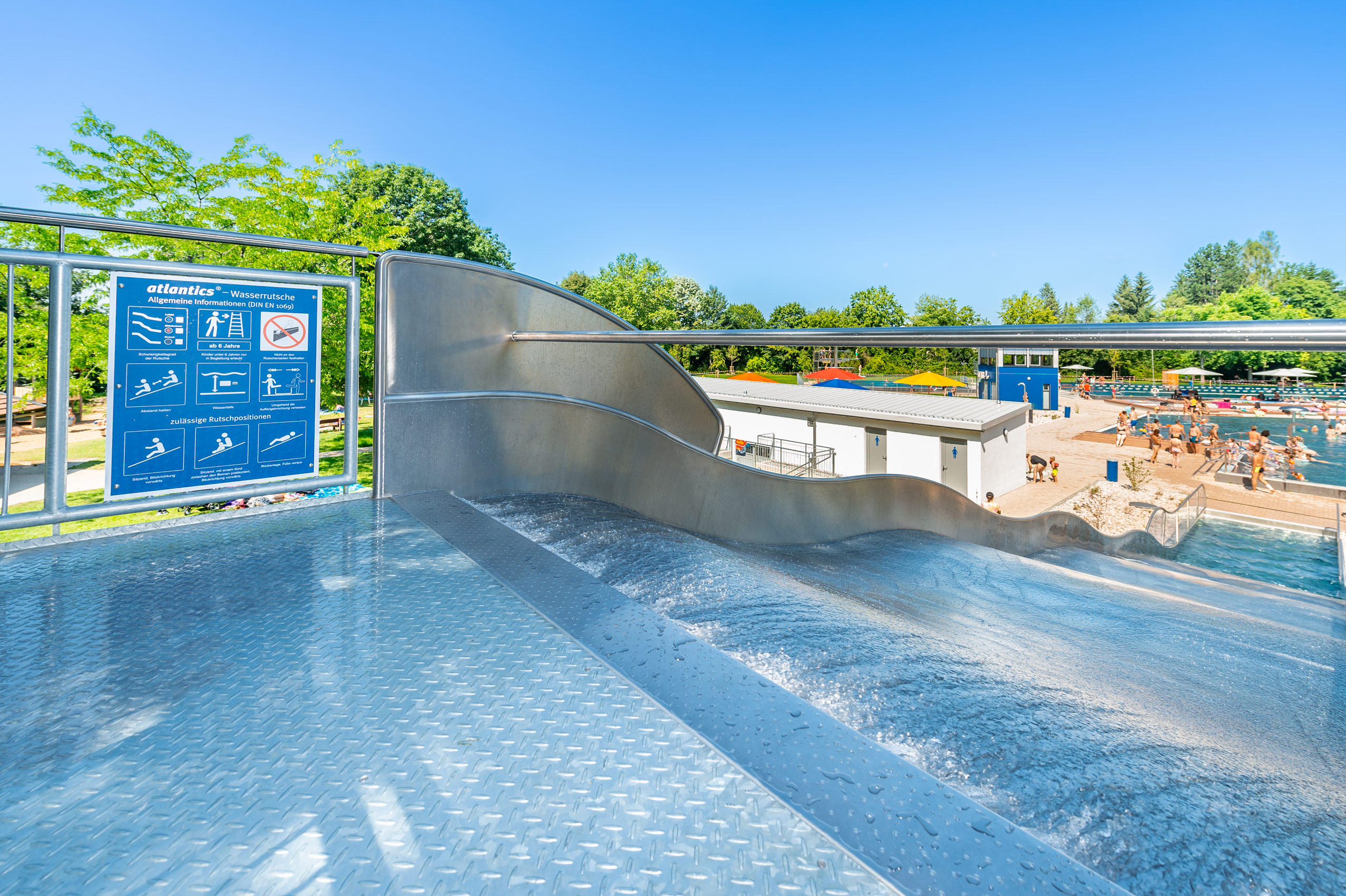 Blick von oben auf die Breitwasserrutsche mit Landebecken aus Edelstahl im Franz-Haberlander-Freibad in Traunreut