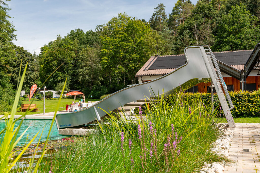 Escorrega de aço inoxidável atlantics na Piscina Natural Autilus em Seßlach, escorrega aquático largo, escorrega aquático de rampa