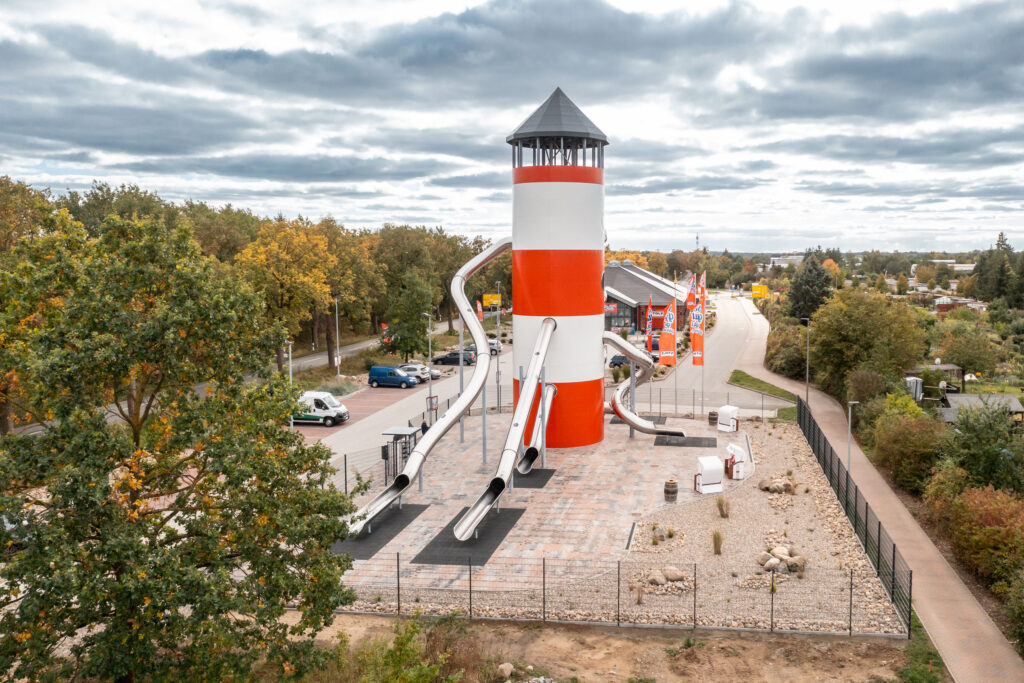 atlantics Edelstahlrutschen Erlebnis Leuchtturm in rot-weiß als Spielplatz, Kaufhaus Stolz in Rechlin und sein Rutschenturm