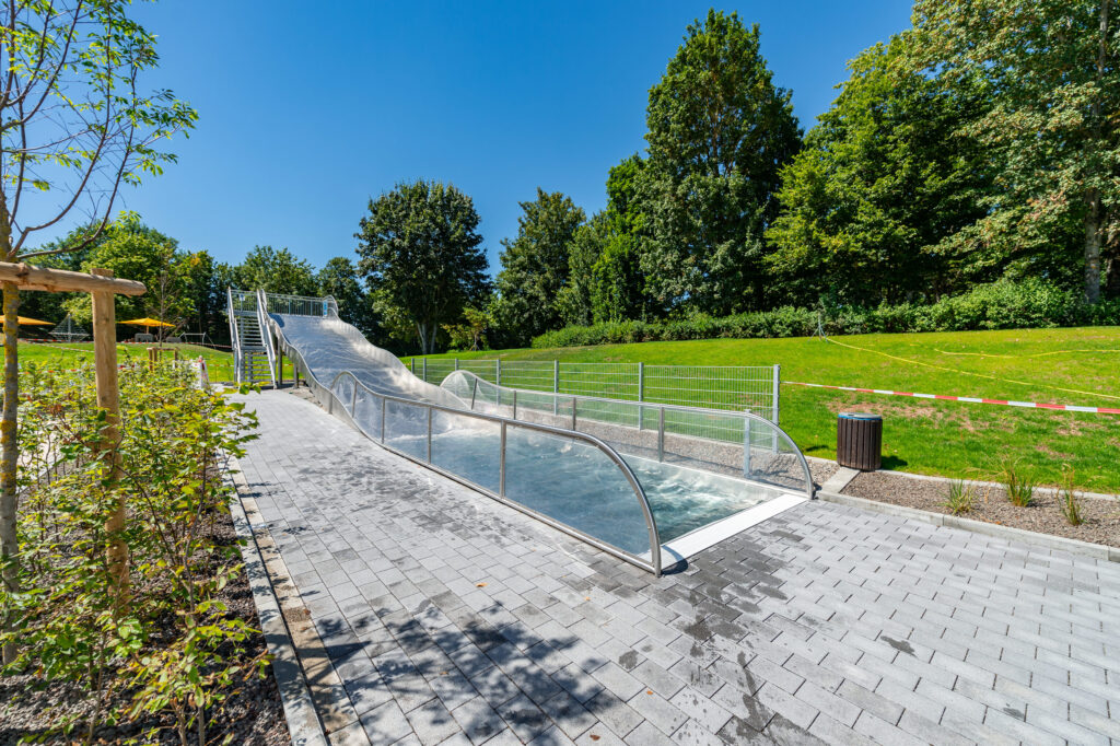 Escorrega de água larga em aço inoxidável com piscina de receção na Piscina Familiar de Haigerloch, vista de baixo