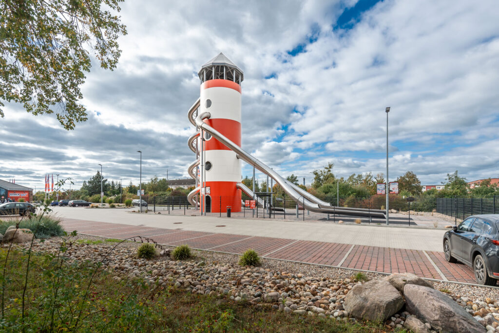 atlantics Edelstahlrutschen Erlebnis Leuchtturm in rot-weiß als Spielplatz, Kaufhaus Stolz in Rechlin und sein Rutschenturm