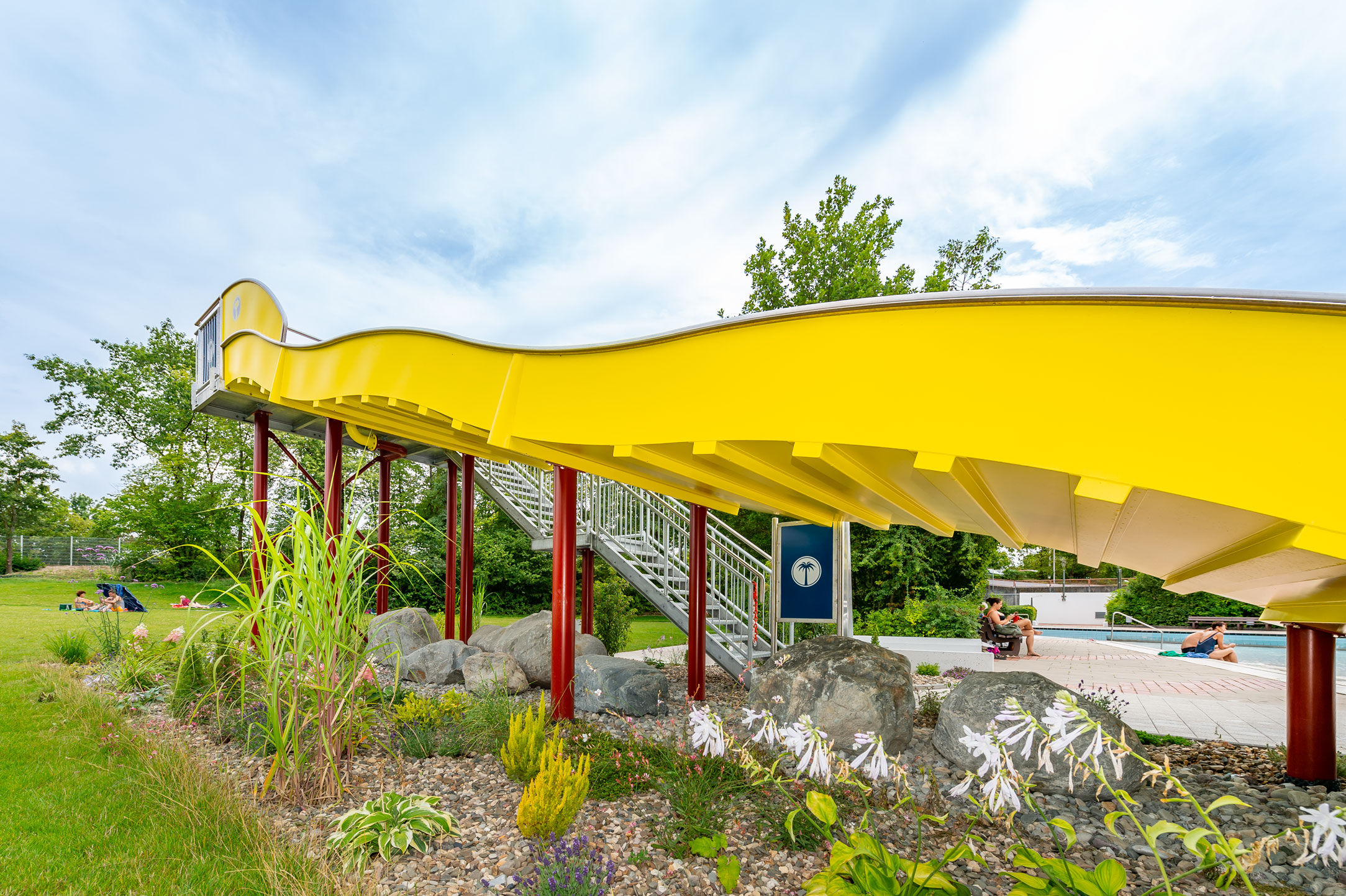 Wasserrutsche mit Landebecken aus V4A Edelstahl im Wellenfreibad in Höchstadt an der Aisch, Außenansicht in gelb