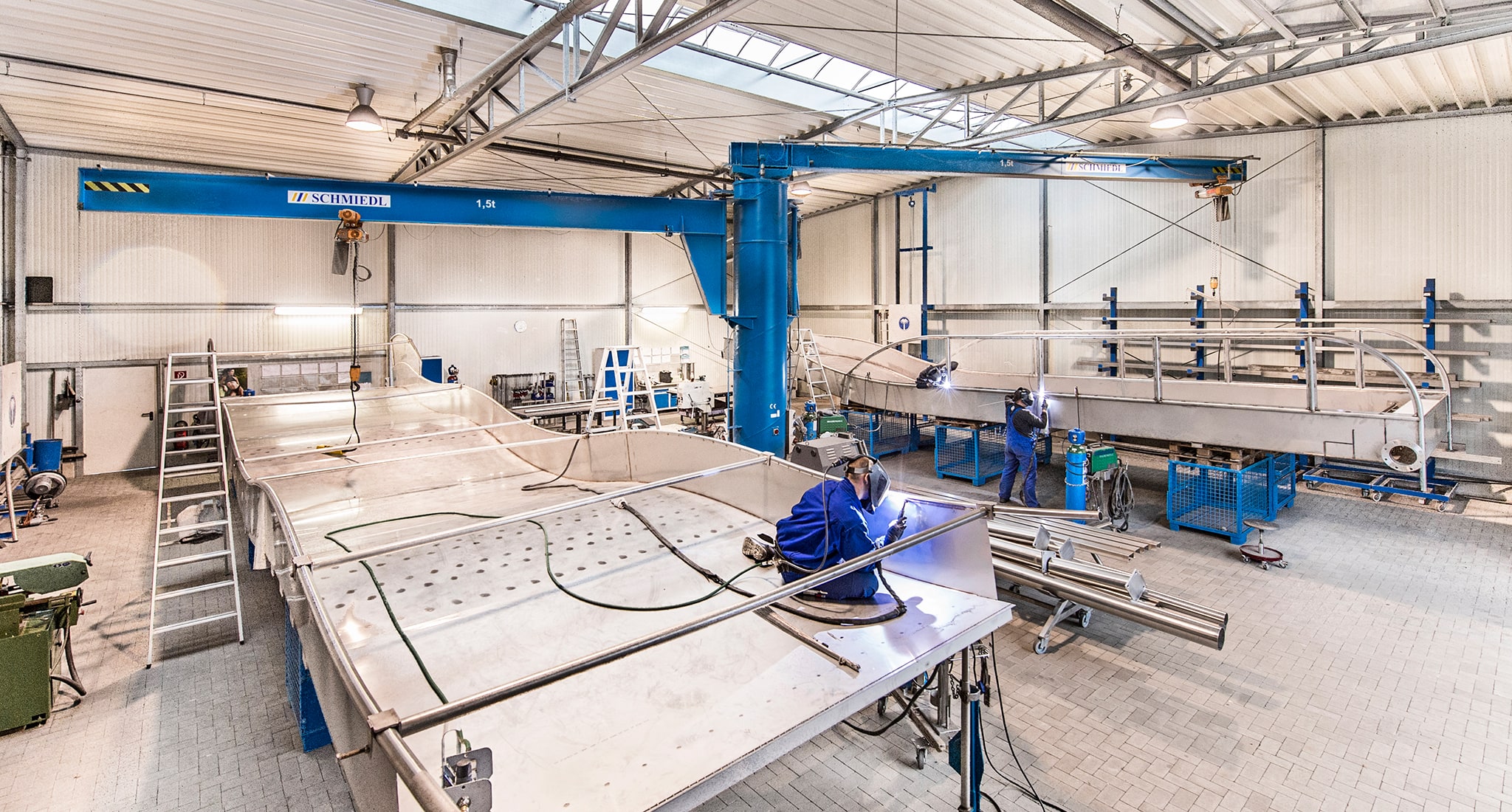 Zwei Mitarbeiter der atlantics GmbH schweißen die Einzelteile der Edelstahlrutschen zusammen.