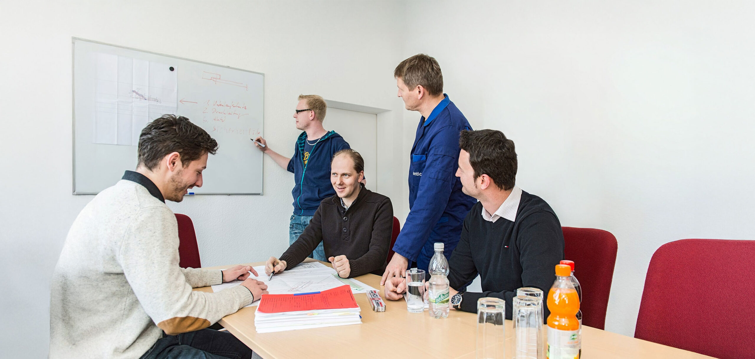 Fünf Mitarbeitende der atlantics GmbH besprechen die Planung der neuen Edelstahlrutschen.