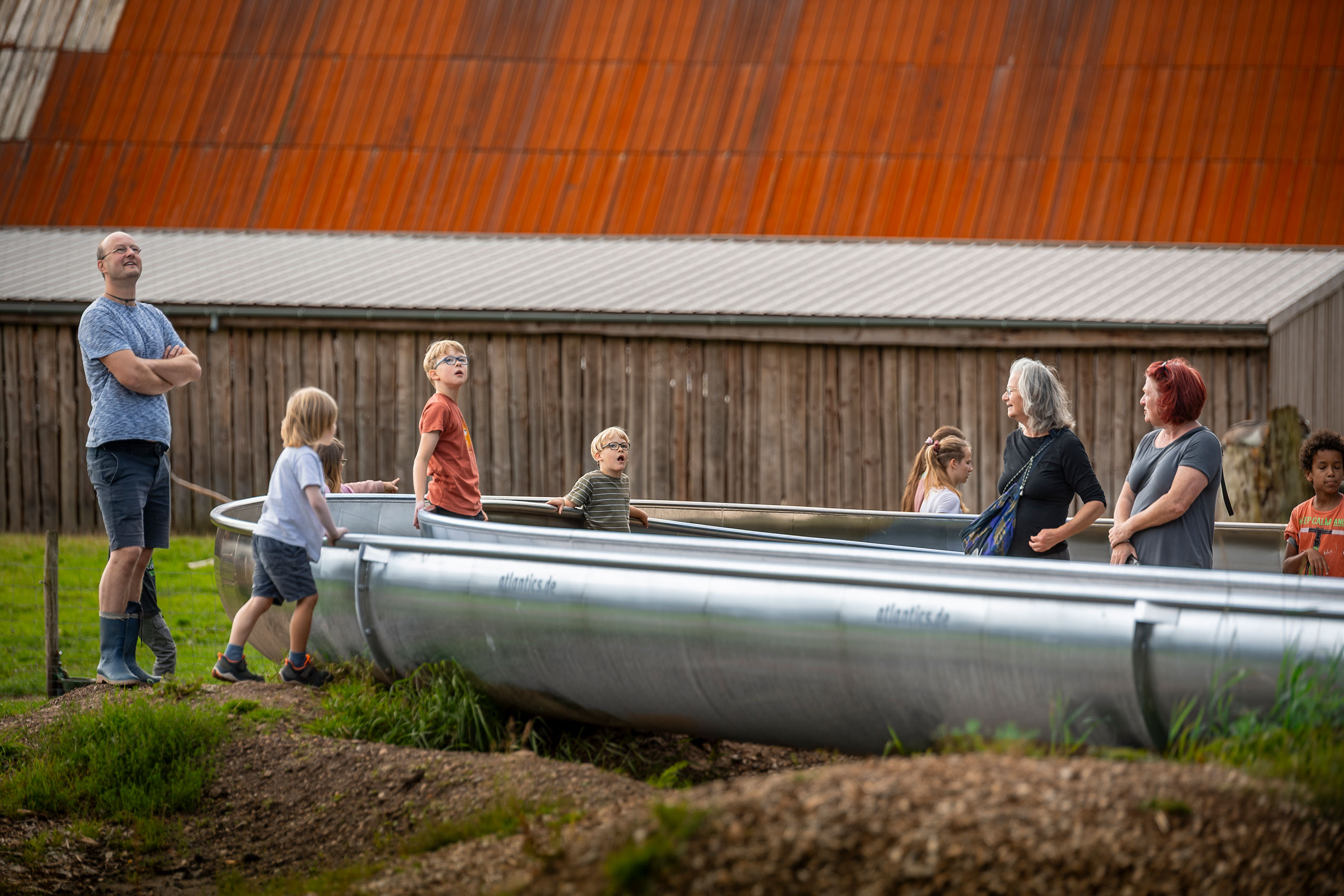 Staunende Kinder und weitere Besucher bei der atlantics Edelstahlrutsche im Freizeitpark WOW Park in Skjern, Dänemark